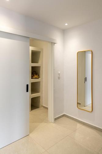 a mirror on a wall in a room at Chrysonisos Suites with Sunset & Seaviews near Kini in Ano Syros