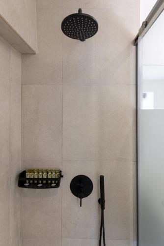 a bathroom with a shower with a glass door at Chrysonisos Suites with Sunset & Seaviews near Kini in Ano Syros