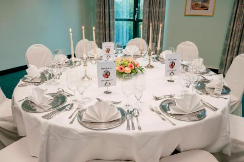 a white table with silverware and flowers on it at Hotel Amadeus Frankfurt in Frankfurt/Main