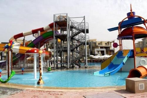 einen Wasserpark mit einer Wasserrutsche und Rutschen in der Unterkunft Villa 4 bedrooms, Sedra resort, North coast in Sidi Kirayr
