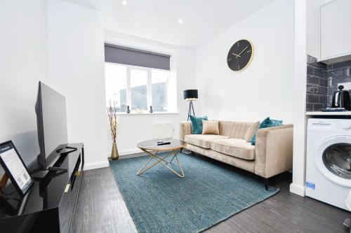 a living room with a couch and a washing machine at Fabulous Compact 1 Bedroom Apartment in Bradford in Bradford