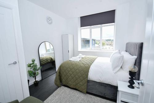a bedroom with a large bed and a mirror at Fabulous Compact 1 Bedroom Apartment in Bradford in Bradford