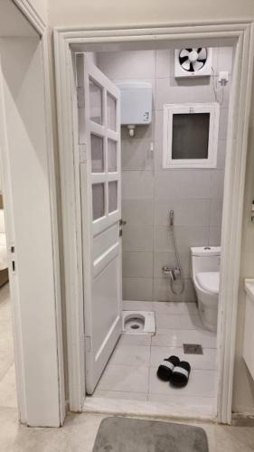 a small bathroom with a toilet and a door at فلل شدا ورقان بالهدا in Al Hada