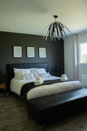 une chambre avec un grand lit avec une tête de lit noire dans l'établissement Les Magnolias à 5 minutes du Lac du Der, à Ambrières