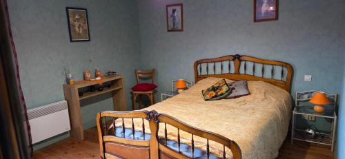 une chambre avec un lit, une table et un bureau dans l'établissement Gite de l'arthour, à Notre-Dame-de-Cenilly