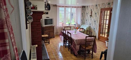 une salle à manger avec une table et une télévision dans l'établissement Gite de l'arthour, à Notre-Dame-de-Cenilly