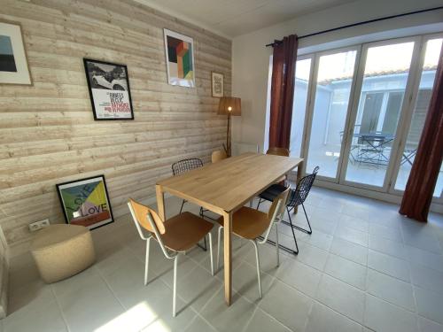 une salle à manger avec une table et des chaises en bois dans l'établissement La Maison Havre de Paix, à Saint-Clément-des-Baleines