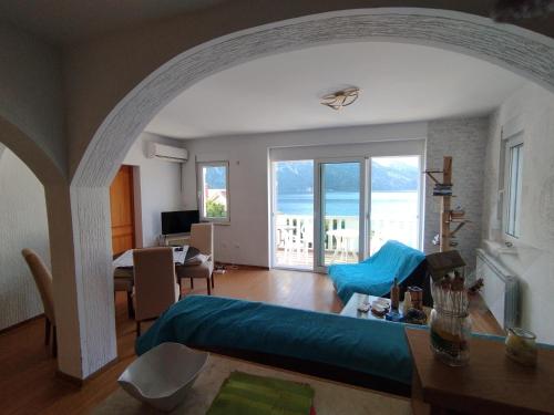 a living room with a blue bed and a room with a view at Amarillys in Donji Morinj