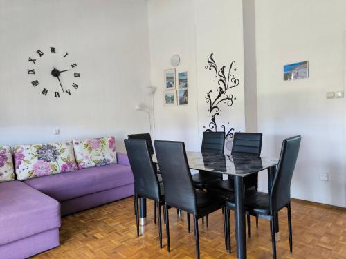 a dining room with a table and a purple couch at Apartments Kočović in Peroj
