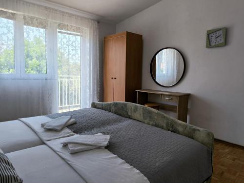 a bedroom with a large bed with a mirror at Apartments Kočović in Peroj