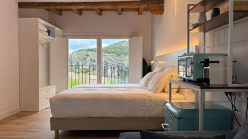 a bedroom with a bed with a television and a window at Mirador Del Rey in Cuenca