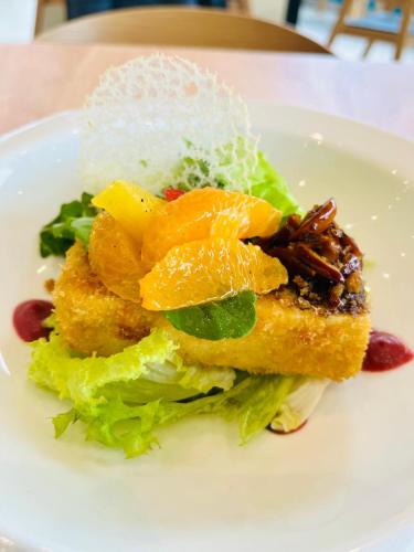 a white plate with a salad with oranges on it at Ocean Boulevard in Iquique