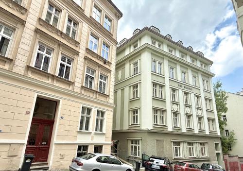 two tall buildings with cars parked in front of them at Oasis Valley in Karlovy Vary