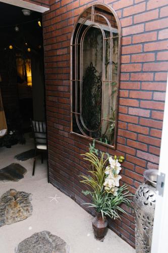 a mirror on the side of a brick wall with flowers at 5th East Hall Bed & Breakfast in American Fork