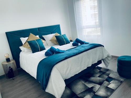 une chambre avec un grand lit bleu avec des chaussures bleues dessus dans l'établissement Appartement T2 Cosy, à Villette-dʼAnthon