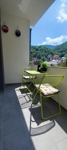 a green table and chairs on a balcony at Apartment Deluxe in Peje