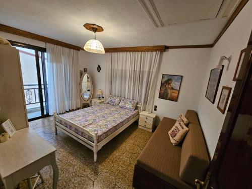 a bedroom with a bed and a couch and a mirror at Villa Kirki in Iraklitsa