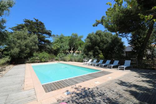 una piscina con tumbonas y una piscina en La Villa des Peupliers, en Les Portes