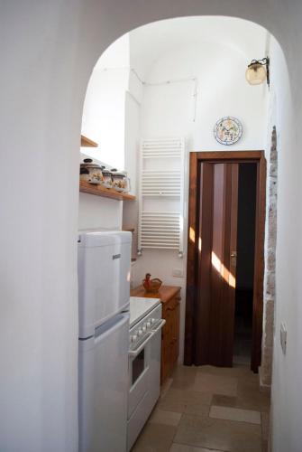 a kitchen with a white refrigerator and a stove at Agriturismo Antonelli Piangevino in Monopoli