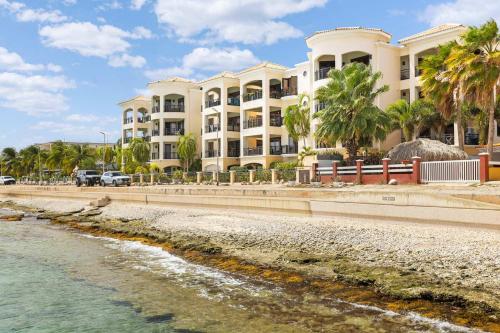 a large white building next to a body of water at Elegancia Ocean View with Cooling Pool in Kralendijk