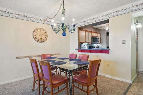 a dining room with a table and chairs and a clock at The Colony at Virginia Beach in Virginia Beach