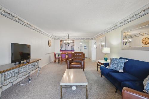 a living room with a blue couch and a tv at The Colony at Virginia Beach in Virginia Beach