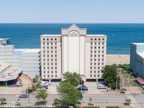 a large white building with a clock tower in front of the ocean at The Colony at Virginia Beach in Virginia Beach
