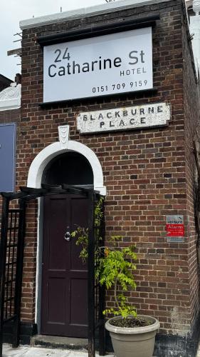 a brick building with a door and a sign on it at 24 Catharine Street Hotel in Liverpool