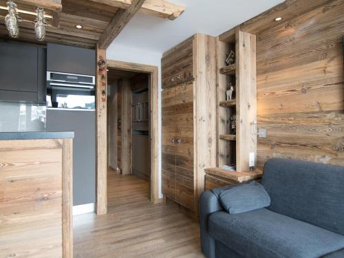- un salon avec un canapé bleu et des murs en bois dans l'établissement Studio luxe 30m², ski au pied, balcon sud/ouest - FR-1-449-149, à Tignes