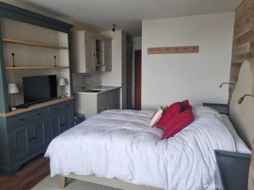 - une chambre avec un lit doté d'oreillers rouges dans l'établissement Studio cosy à Tignes pour 2 personnes, balcon, proche des pistes - FR-1-449-192, à Tignes