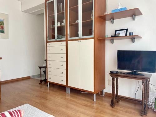 - un salon avec une grande armoire blanche et un bureau dans l'établissement Central & Cosy Menton 2 pièces, à Menton