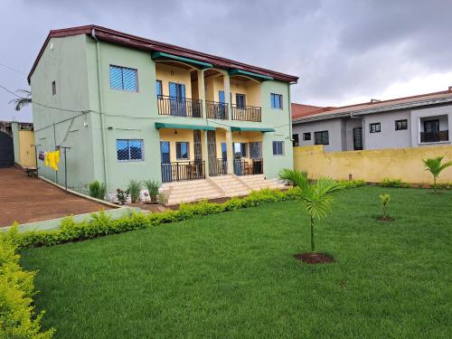 a house with a green lawn in front of it at Résidence TIFI in Yaoundé