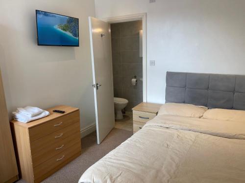 a bedroom with a bed and a bathroom with a toilet at Town centre, very convenient in Newcastle under Lyme