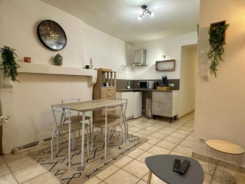 - une cuisine avec une table, des chaises et un comptoir dans l'établissement La terrasse de Grangevieille, à La Celle-sous-Gouzon