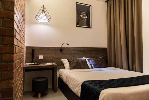 a hotel room with two beds and a desk at Mixx Express Hotel Sunway in Petaling Jaya