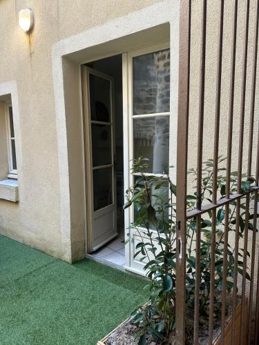 une porte ouverte d'une maison avec une plante dans l'établissement La terrasse de Grangevieille, à La Celle-sous-Gouzon