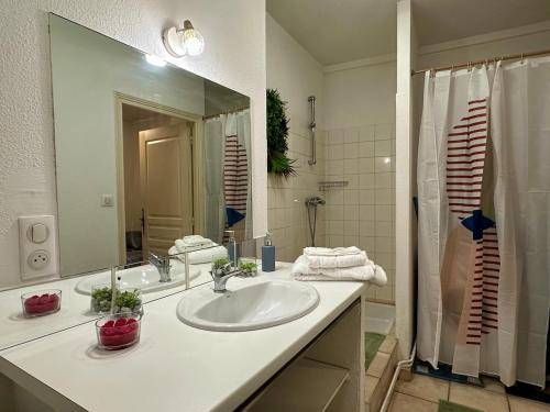une salle de bain avec un lavabo et un grand miroir dans l'établissement La terrasse de Grangevieille, à La Celle-sous-Gouzon