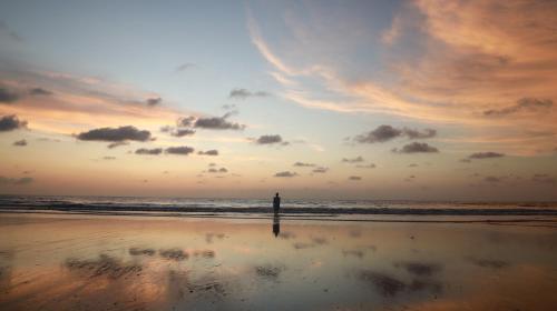 a person standing on a beach with the ocean at Ecolodge Vientos de Yubarta in Nuquí