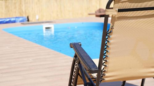 a chair sitting in front of a swimming pool at Esprit Apartmanház in Szajol