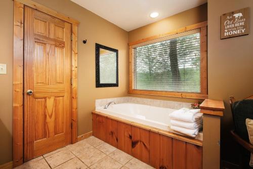 a bathroom with a tub and a window at Pool table, pet friendly, hot tub, & mountain view, 3 bedrooms in Sevierville