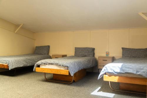 a room with two beds and two night stands at Y Doc at World Horizons Community Hub in Llanelli