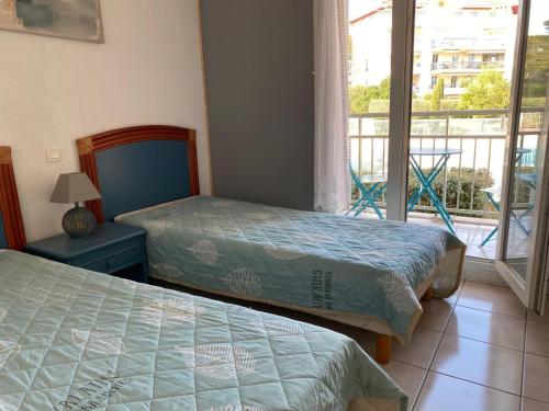 une chambre avec deux lits et un balcon dans l'établissement Confort au calme, à Saint-Aygulf