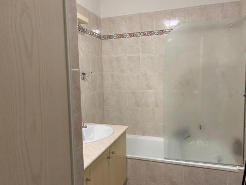 une salle de bain avec une baignoire et un lavabo et une baignoire dans l'établissement Confort au calme, à Saint-Aygulf