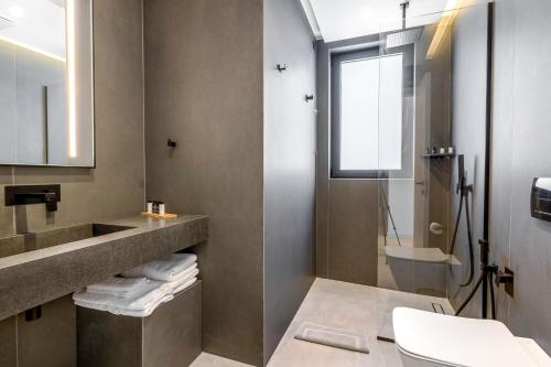 a bathroom with a sink and a toilet and a shower at ALYACHT Premium Hotel in Sarandë