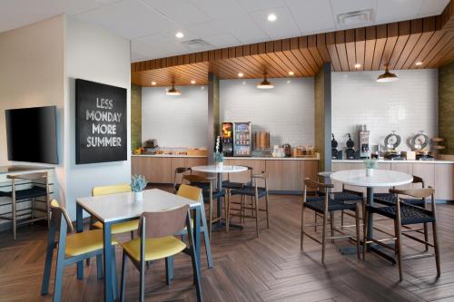 Fairfield Inn & Suites DeSoto Dallas South في دي سوتو: مطعم به طاولات وكراسي ومنضدة