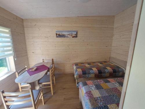 een kamer met twee bedden en een tafel en stoelen bij Ģimenes studija 2 in Pāvilosta