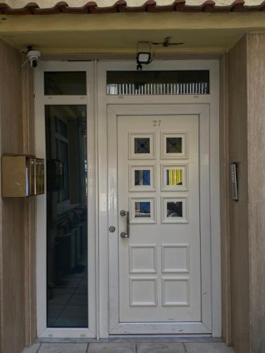 a white door on a building with a window at VATA apartaments in Thessaloniki