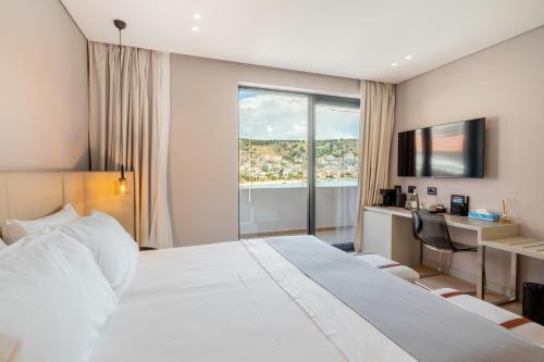 a hotel room with a large bed and a window at ALYACHT Premium Hotel in Sarandë
