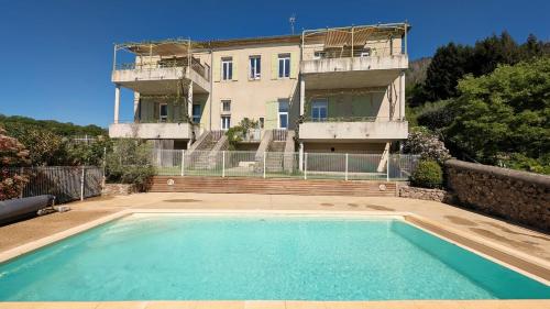 une maison avec piscine devant un immeuble dans l'établissement Gîte Chat Perché, à Vals-les-Bains