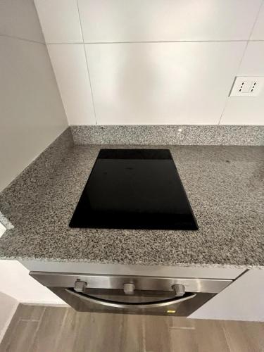 a kitchen counter with a black counter top at Moderno departamento a metros de Movistar Arena in Santiago
